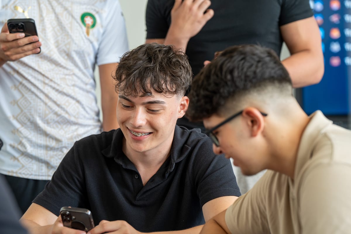 Lachender Teilnehmer mit dem Smartphone in der Hand